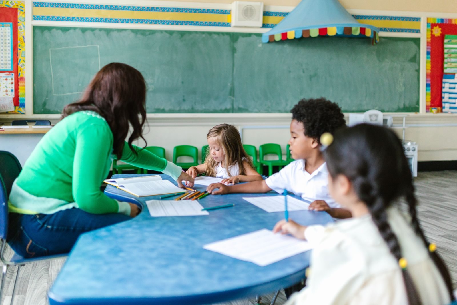 Children practising early learning skills with a teacher